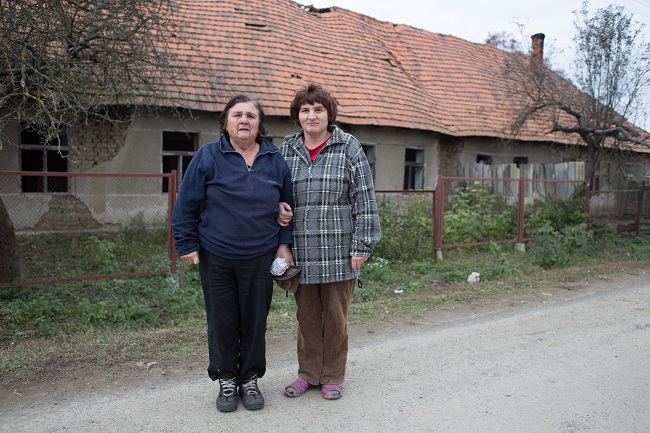 Мешканка села Соломоново Олена Шандорка зі своєю дочкою на тлі свого будинку